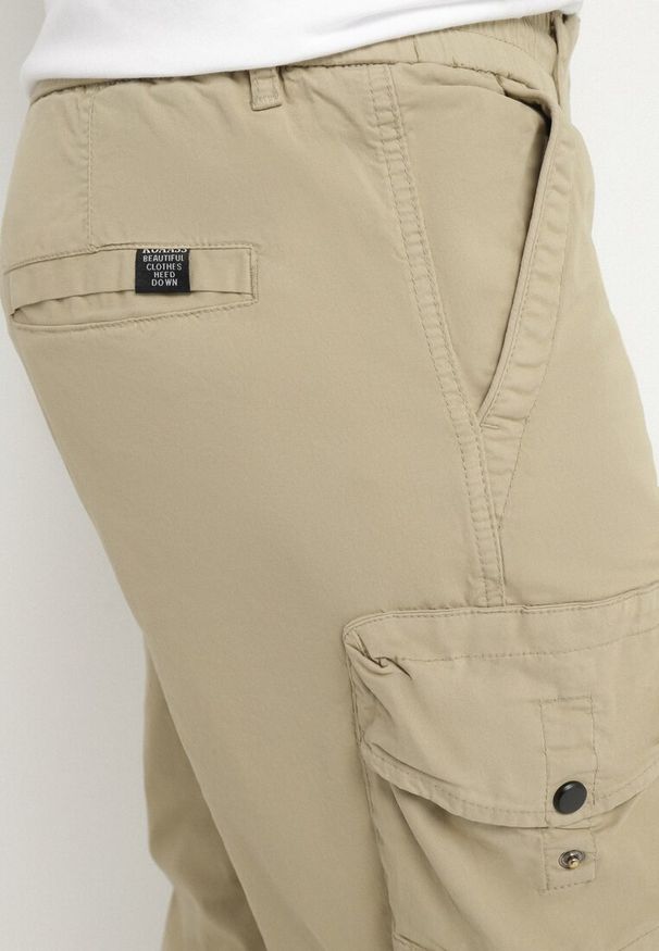 Born2be - Ciemnobeżowe Bawełniane Spodnie Joggery z Kieszeniami z Klapami Lanathia. Okazja: na co dzień. Kolor: beżowy. Materiał: bawełna. Styl: casual
