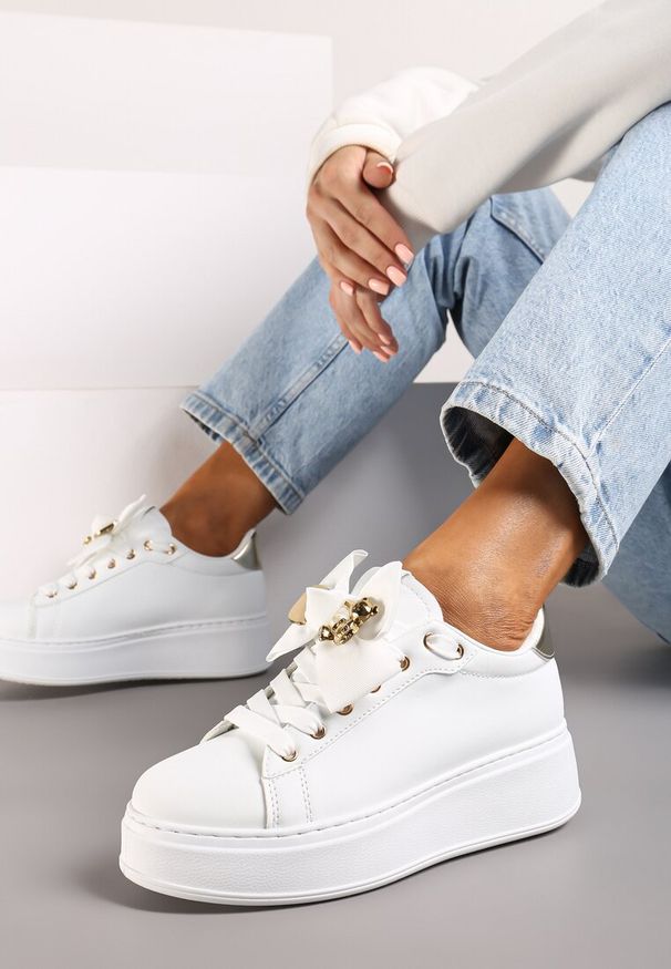 Renee - Biało-Złote Sneakersy Ozdobione Broszką i Kokardką Hrivia. Nosek buta: okrągły. Zapięcie: sznurówki. Kolor: biały. Materiał: jeans. Wzór: aplikacja. Sezon: wiosna, lato