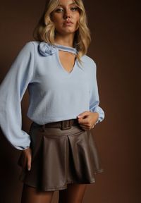 Renee - Jasnoniebieska Bluzka z Ozdobnym Kwiatem Tolna. Kolor: niebieski. Wzór: kwiaty