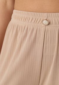 Born2be - Beżowe Spodnie z Wysokim Stanem i Szerokimi Nogawkami Zdobione Guzikiem Kelesh. Okazja: do pracy, na co dzień. Stan: podwyższony. Kolekcja: plus size. Kolor: beżowy. Materiał: tkanina, prążkowany. Długość: długie. Wzór: aplikacja. Styl: elegancki, casual #8