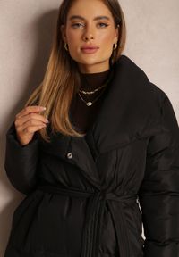 Renee - Czarna Kurtka Długa Pikowana z Wiązanym Paskiem Medguistl. Typ kołnierza: kołnierzyk stójkowy. Kolor: czarny. Materiał: tkanina. Długość: długie. Wzór: gładki. Styl: klasyczny