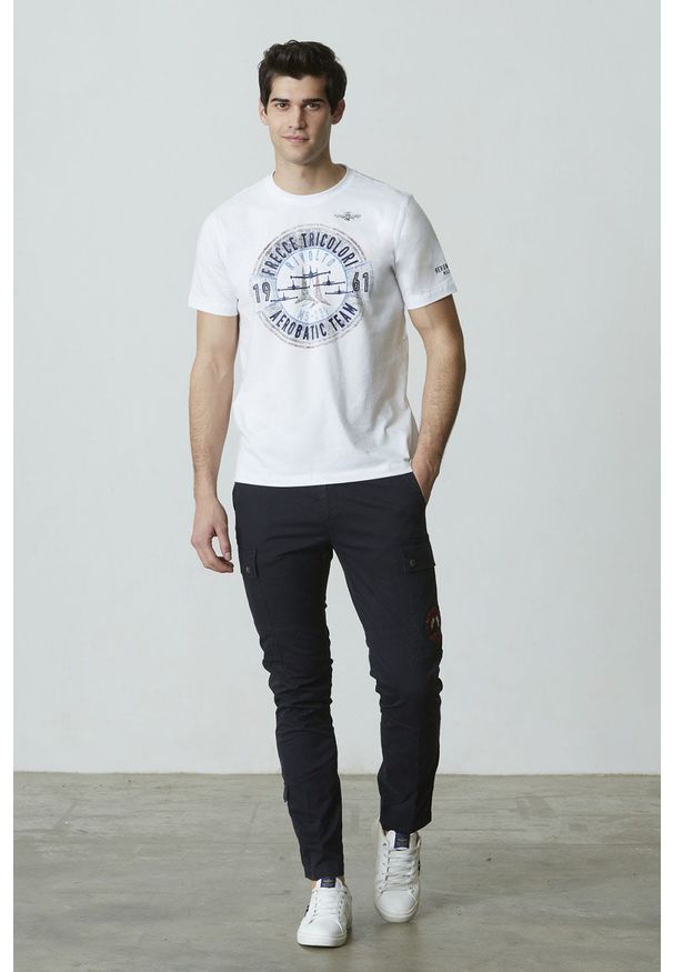 Biały T-shirt z nadrukiem Aeronautica Militare. Kolor: biały. Materiał: dzianina, elastan, bawełna. Długość rękawa: krótki rękaw. Długość: krótkie. Wzór: nadruk. Styl: klasyczny