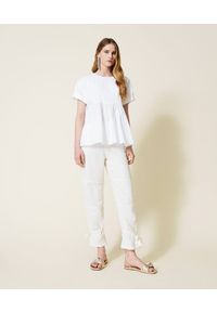 TwinSet - Biała asymetryczna bluzka z falbaną Twinset. Typ kołnierza: kołnierz z falbankami. Kolor: biały. Materiał: bawełna, elastan, jersey. Długość: krótkie