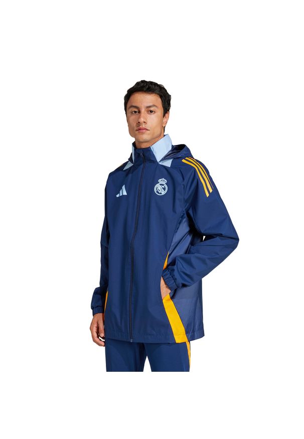 Adidas - Kurtka wodoodporna Real Madrid Tiro 2024/25 Competition. Kolor: niebieski, wielokolorowy, pomarańczowy. Materiał: dresówka. Sport: outdoor, piłka nożna