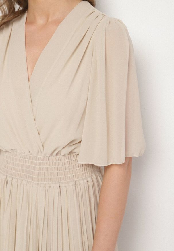 Born2be - Beżowy Plisowany Kombinezon o Kopertowym Kroju z Gumką w Talii Ameddie. Okazja: na co dzień. Kolor: beżowy. Styl: elegancki, casual