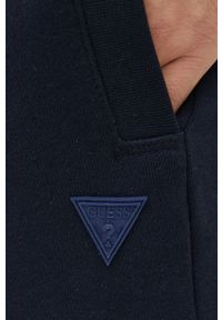 Guess spodnie dresowe kolor granatowy melanżowe. Kolor: niebieski. Materiał: dresówka. Wzór: melanż #2