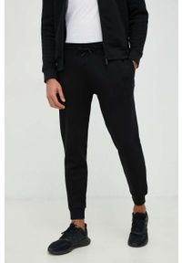 Guess spodnie dresowe kolor czarny melanżowe. Kolor: czarny. Materiał: dresówka. Wzór: melanż