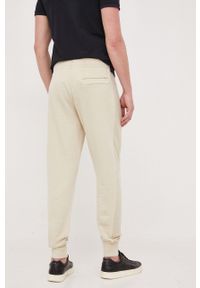 Calvin Klein Jeans spodnie dresowe bawełniane kolor beżowy gładkie. Kolor: beżowy. Materiał: bawełna, dresówka. Wzór: gładki #3