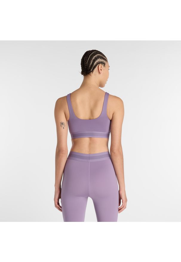 Biustonosz do treningu New Balance AC WB61Q0QKAA5 – fioletowy. Kolor: fioletowy. Materiał: tkanina, poliester, materiał. Rodzaj stanika: wyciągane miseczki, push-up. Sport: fitness