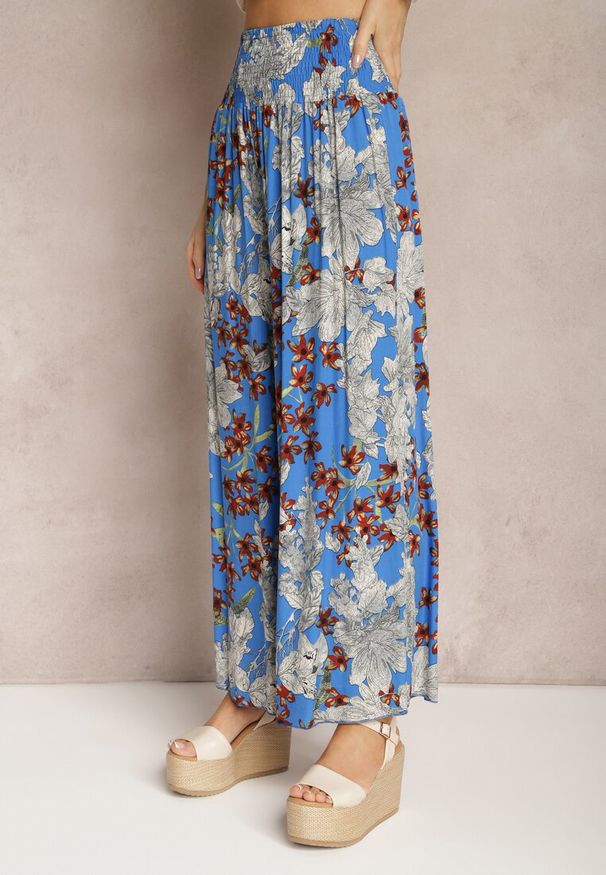 Renee - Niebieskie Spodnie z Wiskozy z Gumką w Talii i Szerokimi Nogawkami w Kwiaty Selinia. Kolor: niebieski. Materiał: wiskoza. Wzór: kwiaty