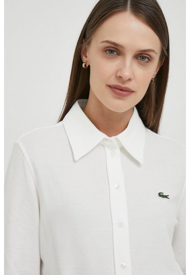Lacoste koszula bawełniana damska kolor beżowy regular z kołnierzykiem klasycznym. Typ kołnierza: kołnierzyk klasyczny. Kolor: beżowy. Materiał: bawełna. Długość rękawa: długi rękaw. Długość: długie. Styl: klasyczny