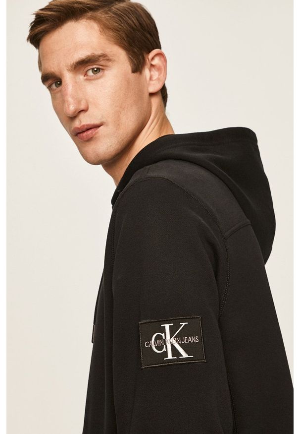 Calvin Klein Jeans - Bluza. Okazja: na co dzień. Typ kołnierza: kaptur. Kolor: czarny. Materiał: dzianina. Wzór: gładki. Styl: casual