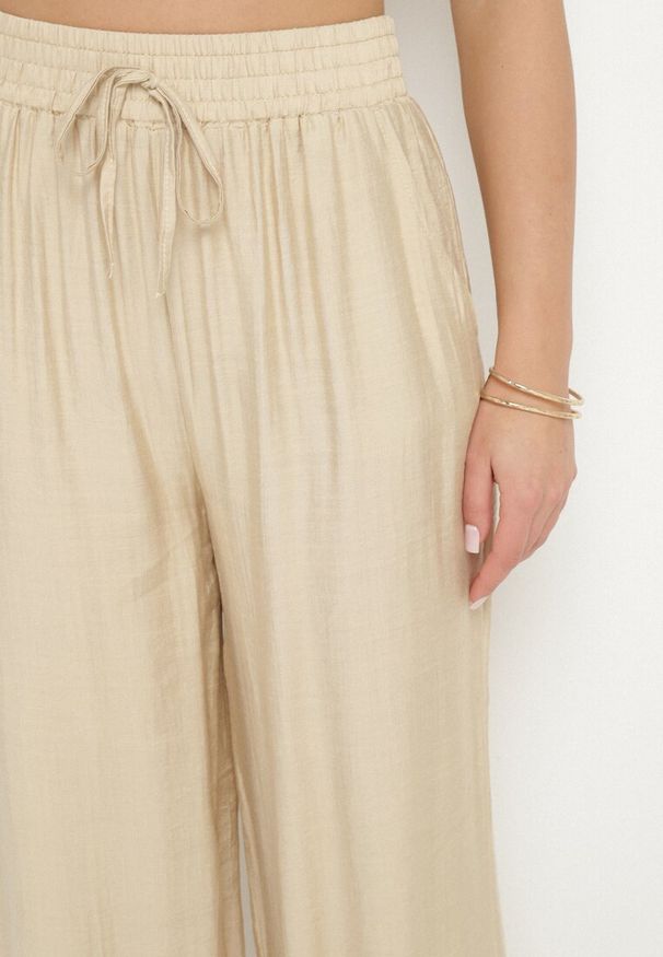 Born2be - Beżowe Szerokie Spodnie Palazzo z Wysokim Stanem i Wiązaniem Myrlevia. Okazja: na co dzień. Stan: podwyższony. Kolor: beżowy. Styl: klasyczny, casual, elegancki