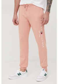 TOMMY HILFIGER - Tommy Hilfiger spodnie dresowe bawełniane męskie kolor różowy z aplikacją. Kolor: różowy. Materiał: bawełna, dresówka. Wzór: aplikacja #1