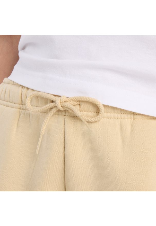 Spodenki damskie New Balance WB61Y80AABC – żółte. Kolor: żółty. Materiał: bawełna, dzianina, poliester. Długość: krótkie. Wzór: napisy