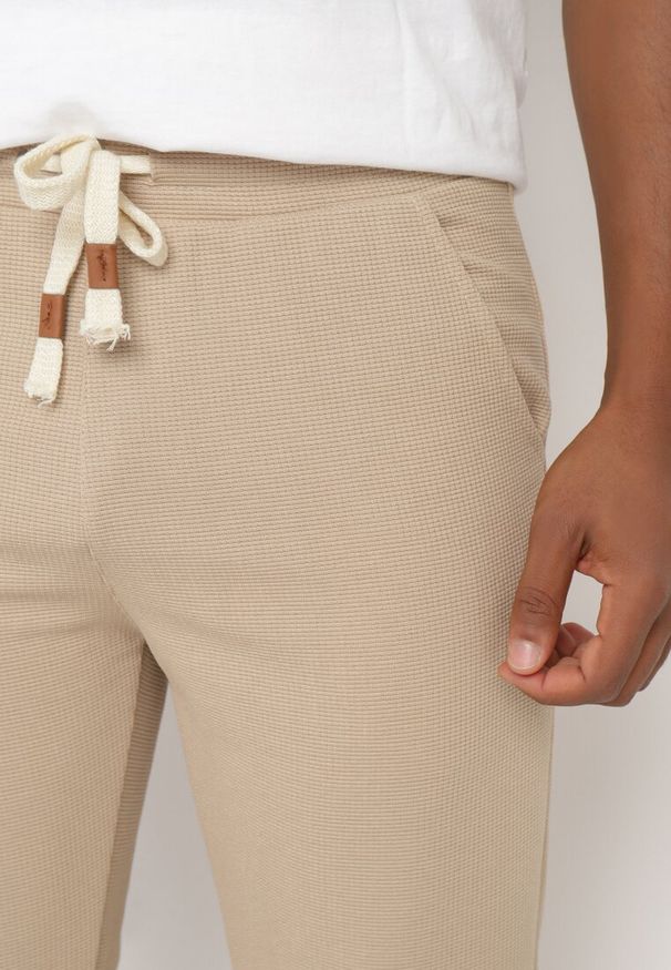 Born2be - Ciemnobeżowe Spodnie Dresowe z Bawełną Wysokim Stanem i Ozdobnymi Sznurkami Arsiala. Okazja: na co dzień. Stan: podwyższony. Kolor: beżowy. Materiał: bawełna, dresówka. Długość: długie. Wzór: aplikacja. Styl: casual