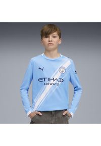 Puma - Młodzieżowa koszulka domowa z długim rękawem Manchester City 25/26 PUMA. Kolor: niebieski, wielokolorowy, biały. Długość rękawa: długi rękaw. Długość: długie. Wzór: aplikacja, paski. Sport: piłka nożna