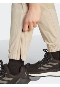 Adidas - adidas Spodnie dresowe Terrex Utilitas Hiking Zip-Off Tracksuit Bottoms HZ9046 Beżowy Regular Fit. Kolor: beżowy. Materiał: syntetyk