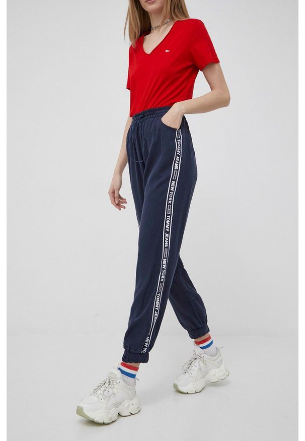 Tommy Jeans spodnie damskie kolor granatowy z nadrukiem. Kolor: niebieski. Materiał: materiał, tkanina, jedwab, lyocell. Wzór: nadruk