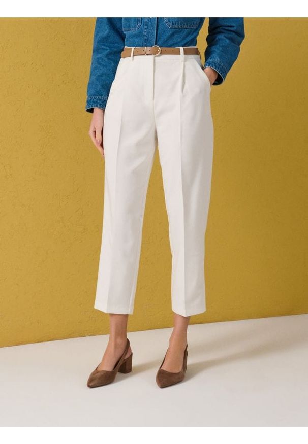 Sinsay - Spodnie carrot z nogawką w kant i paskiem - kremowy. Kolor: kremowy