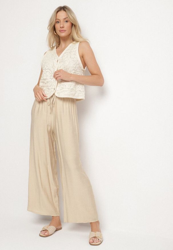 Born2be - Beżowe Szerokie Spodnie z Wysokim Stanem Ozdobione Wiązaniem Teliriela. Okazja: na co dzień. Stan: podwyższony. Kolor: beżowy. Wzór: aplikacja. Styl: klasyczny, casual
