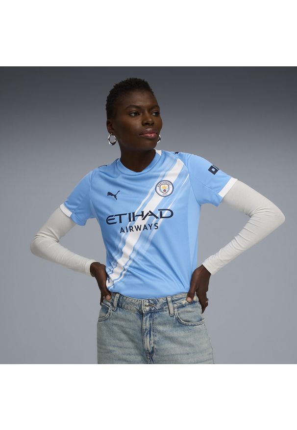 Puma - Damska koszulka domowa Manchester City 25/26 PUMA Team Light Blue White. Kolor: niebieski, wielokolorowy, biały. Wzór: aplikacja, paski. Sport: piłka nożna