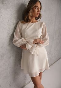 Renee - Beżowa Sukienka Vices Ozdobiona Transparentnymi Rękawami i Kropkami Celziva. Okazja: na co dzień. Kolor: beżowy. Materiał: koronka. Wzór: aplikacja, kropki. Styl: casual, elegancki #1