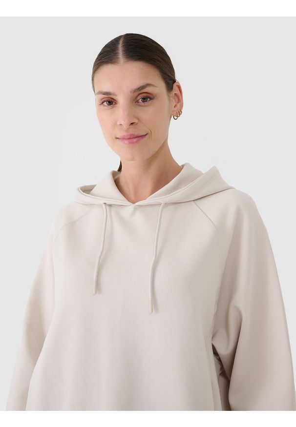 4f - 4F Bluza dresowa nierozpinana z kapturem damska - beżowa S. Okazja: na co dzień. Typ kołnierza: kaptur. Kolor: beżowy. Materiał: dresówka. Długość rękawa: raglanowy rękaw. Wzór: gładki, ze splotem. Styl: sportowy, casual. Sport: fitness