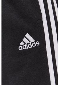 Adidas - adidas Spodnie damskie kolor czarny gładkie. Kolor: czarny. Wzór: gładki