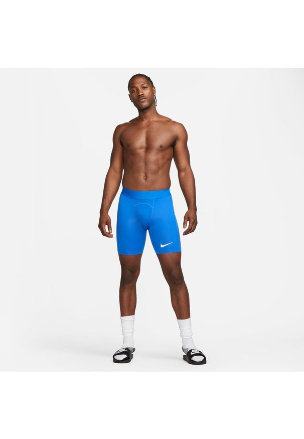 Spodnie treningowe męskie Nike Pro Drifit Strike. Kolor: niebieski, wielokolorowy, biały. Technologia: Dri-Fit (Nike). Długość: krótkie. Sport: piłka nożna
