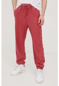 Champion spodnie dresowe męskie kolor różowy gładkie. Kolor: różowy. Materiał: dresówka. Wzór: gładki