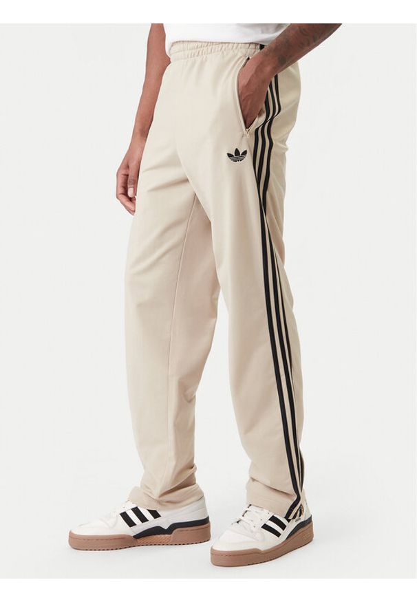 Adidas - adidas Spodnie dresowe Firebird KE6679 Beżowy Loose Fit. Kolor: beżowy. Materiał: syntetyk