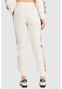 Guess - GUESS Kremowe spodnie damskie z lampasami w logo. Kolor: kremowy. Materiał: bawełna. Wzór: aplikacja #4