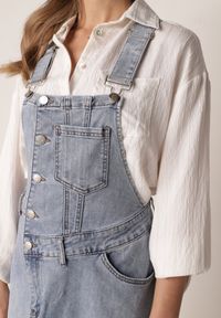 Born2be - Niebieska Trapezowa Sukienka Jeansowa o Kroju Ogrodniczki z Bawełną Peimellia. Okazja: na co dzień. Kolor: niebieski. Materiał: bawełna, jeans. Typ sukienki: trapezowe. Styl: casual #3