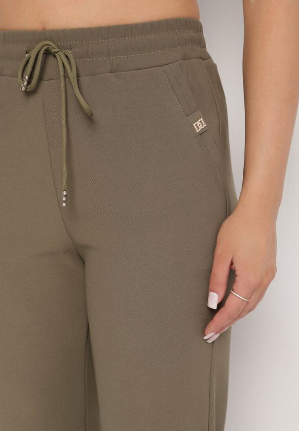 Born2be - Ciemnozielone Szerokie Spodnie z Wiązaniem i Metalicznymi Aplikacjami Mairae. Okazja: na co dzień. Kolor: zielony. Wzór: aplikacja. Styl: casual, elegancki