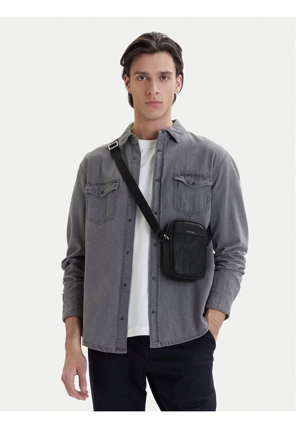 Calvin Klein Saszetka Emblem Aop Emboss Slim Reporter LV04D3371G Czarny. Kolor: czarny. Materiał: skóra