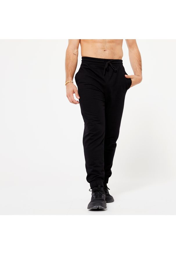 DOMYOS - Spodnie dresowe męskie Domyos Gym & Pilates. Kolor: czarny. Materiał: materiał, bawełna, poliester. Wzór: ze splotem. Sport: joga i pilates