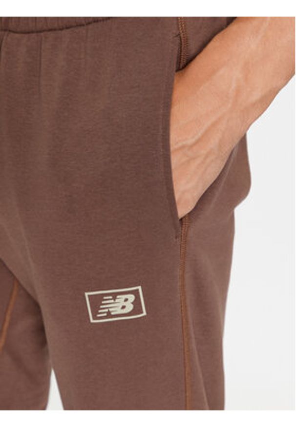 New Balance Spodnie dresowe NB Essentials Sweatpant MP33509 Brązowy Regular Fit. Kolor: brązowy. Materiał: syntetyk, bawełna