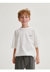 Reserved - T-shirt oversize z naszywką - złamana biel. Materiał: dzianina, bawełna. Wzór: aplikacja #1