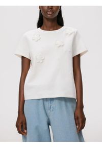 Reserved - T-shirt z kwiatową aplikacją - złamana biel. Materiał: dzianina, bawełna. Wzór: aplikacja, kwiaty