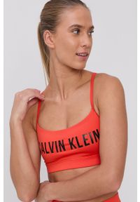 Calvin Klein Performance - Biustonosz sportowy. Kolor: pomarańczowy. Rodzaj stanika: odpinane ramiączka. Wzór: nadruk