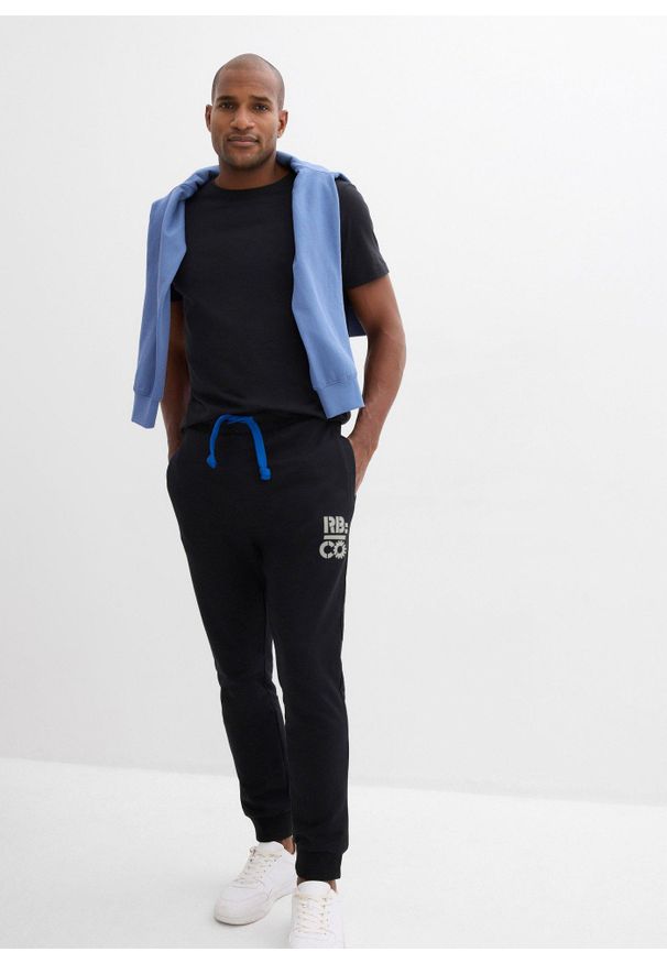 bonprix - Spodnie sportowe z kontrastowymi elementami. Kolor: czarny. Materiał: dresówka, poliester. Wzór: nadruk. Styl: sportowy