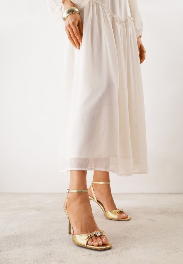 Renee - Złote Sandały VICES na Szpilce Zdobione Kokardą i Aplikacją z Cyrkoniami Sireilora. Zapięcie: pasek. Kolor: złoty. Materiał: satyna. Wzór: aplikacja. Obcas: na szpilce. Styl: glamour