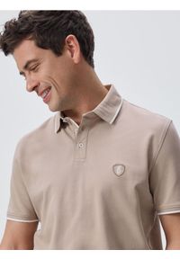 Reserved - Koszulka polo regular fit - beżowy. Typ kołnierza: polo. Kolor: beżowy. Materiał: dzianina, bawełna