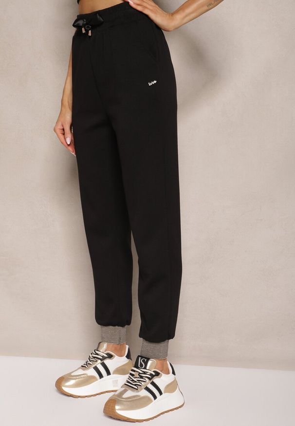 Renee - Czarne Spodnie Dresowe z Ozdobną Wstążką i Metaliczną Nicią Evelzia. Okazja: na co dzień, na spacer. Kolor: czarny. Materiał: dresówka. Styl: elegancki, casual