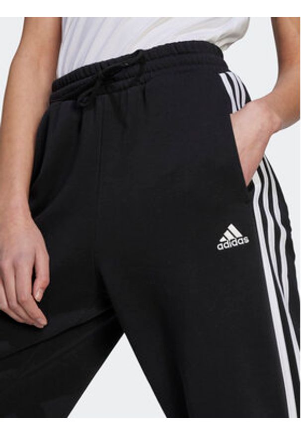Adidas - adidas Spodnie dresowe Essentials 3-Stripes Open Hem Fleece HZ5748 Czarny Loose Fit. Kolor: czarny. Materiał: bawełna