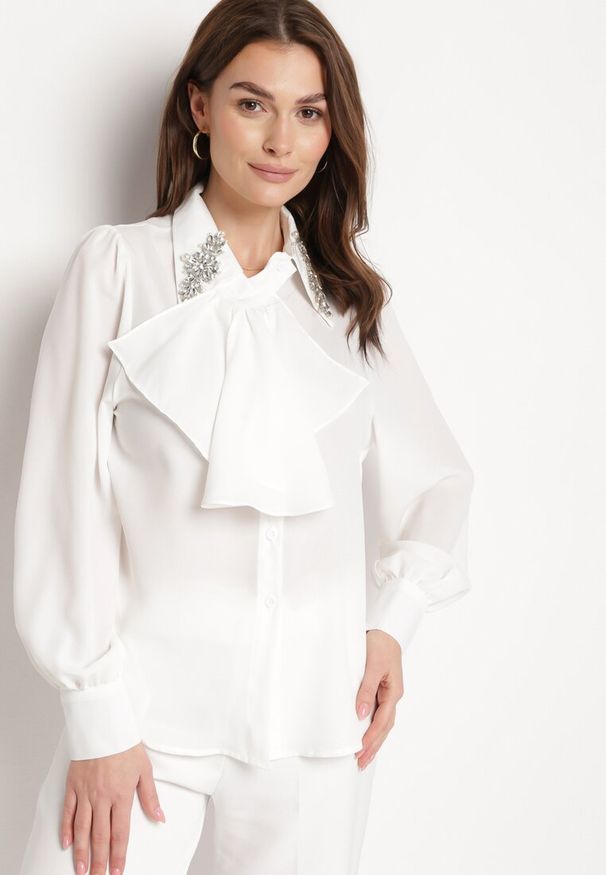 Born2be - Biała Koszula z Falbanką i Ozdobnymi Broszkami z Cyrkoniami Ophiriel. Okazja: na co dzień. Typ kołnierza: kołnierzyk klasyczny. Kolor: biały. Materiał: tkanina, materiał. Długość: długie. Wzór: gładki, aplikacja. Styl: casual, klasyczny