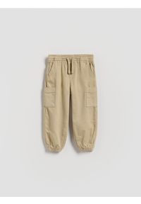 Reserved - Wysokoelastyczne joggery cargo - beżowy. Kolor: beżowy. Materiał: bawełna, tkanina
