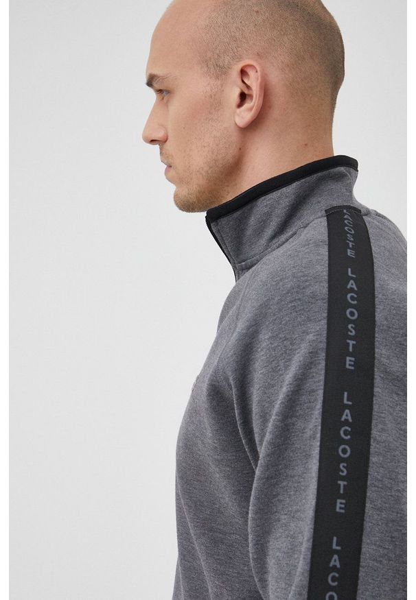 Lacoste Bluza męska kolor szary gładka. Okazja: na co dzień. Kolor: szary. Materiał: dzianina. Długość rękawa: raglanowy rękaw. Wzór: gładki. Styl: casual