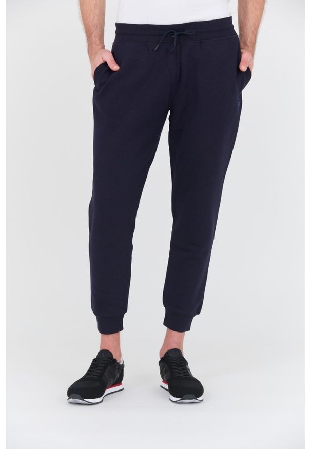 Guess - GUESS Granatowe spodnie dresowe Aldwin. Kolor: niebieski. Materiał: dresówka